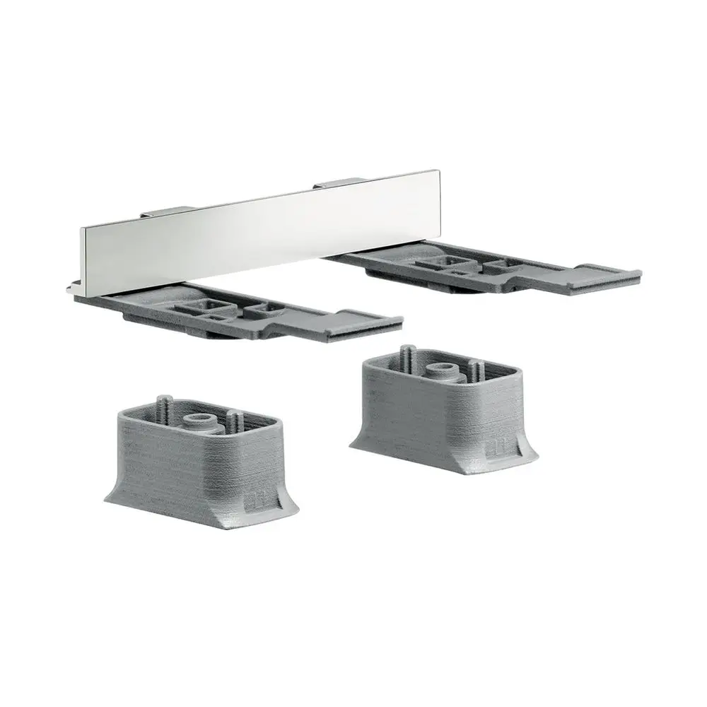 AXOR Universaladapterset mit zwei grauen Basisteilen und einem gebürsteten Nickelblech zur Befestigung oder Anpassung von Armaturen.